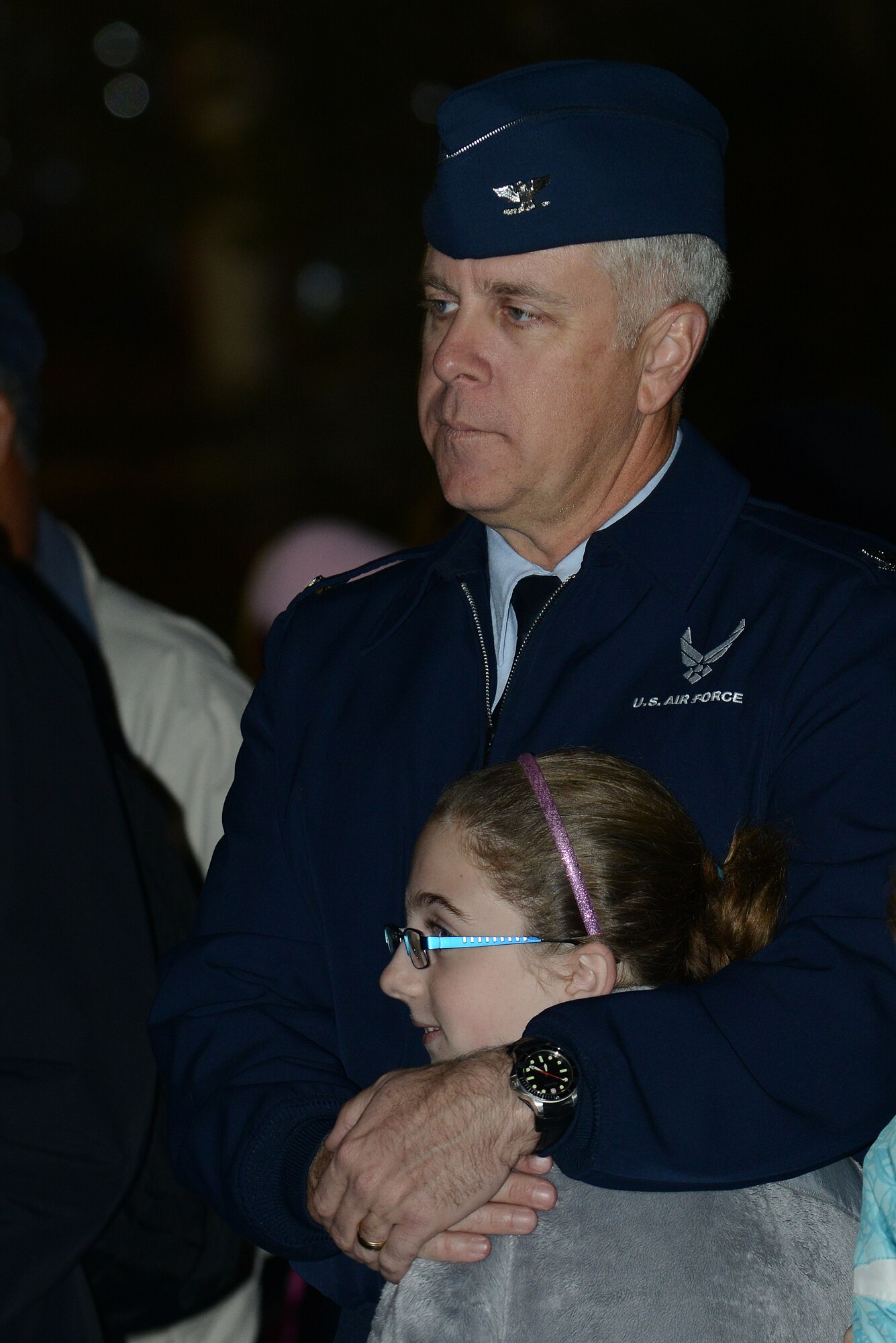 U.S. Air Force Col. John J. Allen Jr., 633rd Air Base Wing commander, and his daughter listen to the choir during the Langley Christmas tree lighting ceremony at Langley Air Force Base, Va., Dec. 3, 2013. This year marks the 46th year of the annual base tradition. (U.S. Air Force photo by Airman 1st Class Kimberly Nagle/Released)