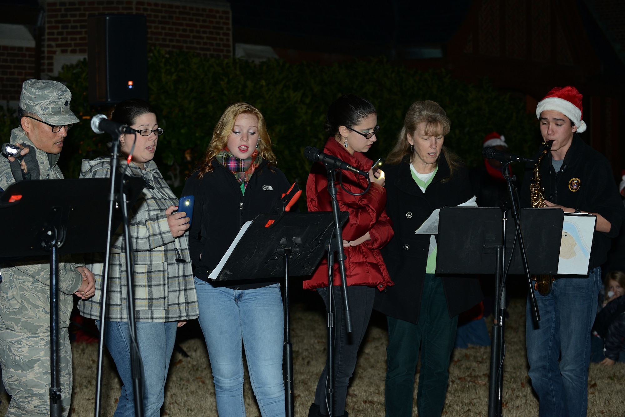 Members of the Bethel Chapel Catholic Worship Team sing Christmas carols at the Langley Christmas tree lighting ceremony at Langley Air Force Base, Va., Dec. 3, 2013. The event also included music, poetry readings and a visit from Santa Claus. (U.S. Air Force photo by Airman 1st Class Kimberly Nagle/Released)