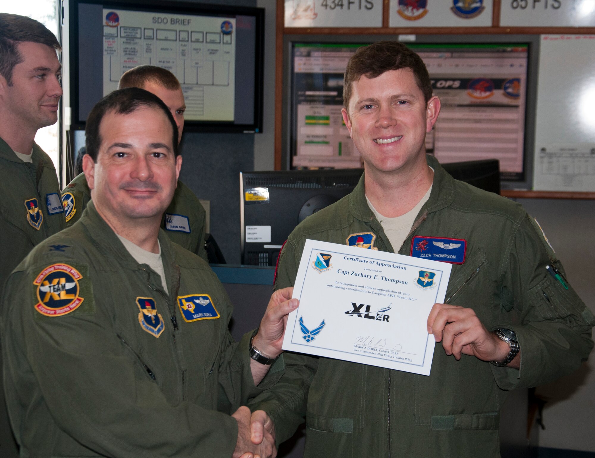 Capt. Zachary Thompson, right, 434th Flying Training Squadron chief of training, poses with Col. Mark Doria, left, 47th Flying Training Wing vice commander, after being presented the XLer of the week award here Nov. 27, 2013. The XLer is a weekly award chosen by wing leadership and given to those who consistently make outstanding contributions to Laughlin and their unit. (U.S. Air Force photo/Joel Langton)