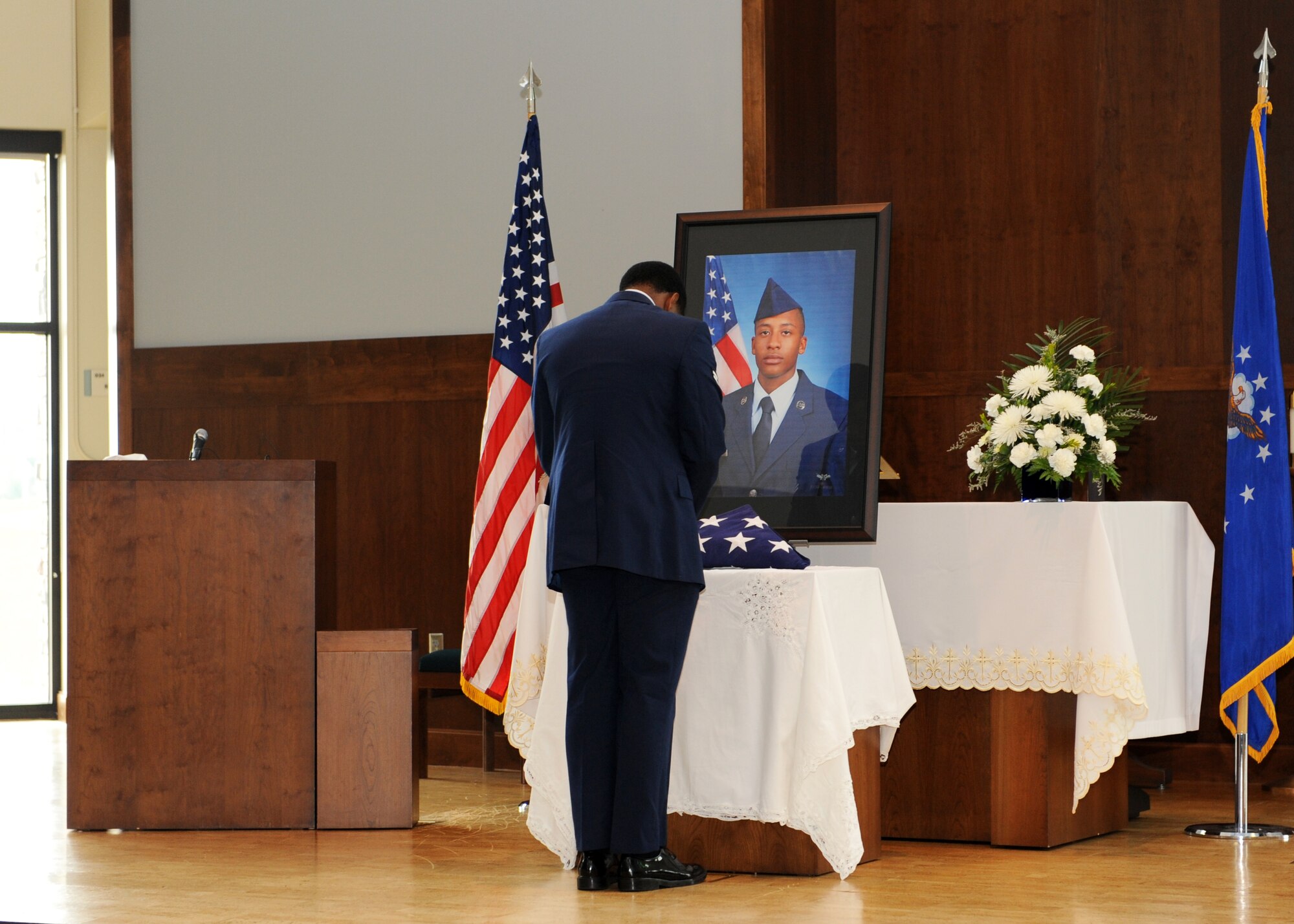 An Airman pauses at the portrait of Airman 1st Class Shaquille Hargrove that is displayed at the chapel July 24, 2013, on Buckley Air Force Base, Colo. The chapel was filled to standing-room-only capacity for Hargrove, a 2nd Space Warning Squadron satellite systems operator, who was killed in an incident at 15th and Market Streets in downtown Denver July 13. (U.S. Air Force photo by Senior Airman Marcy Glass/Released)
