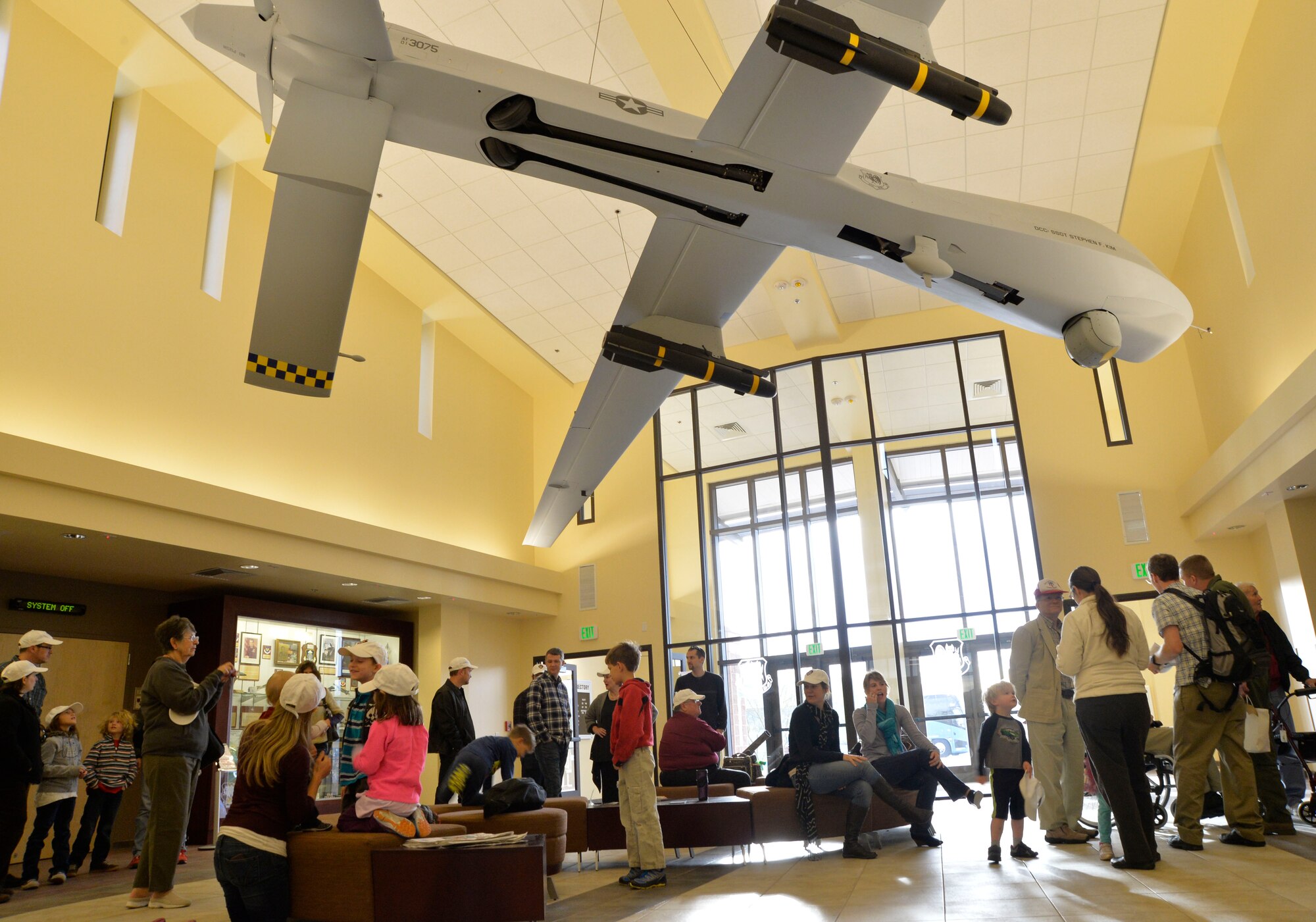 Retired U.S. Air Force colonel Linus Upson Jr. and his family gather in the main lobby of the base headquarters building during a tour Nov. 27, 2013. Upson, who was the base commander in 1945, met with the current 432nd Wing/432nd Air Expeditionary Wing Commander, Col. James Cluff. (U.S. Air Force photo by Senior Airman A.K.)