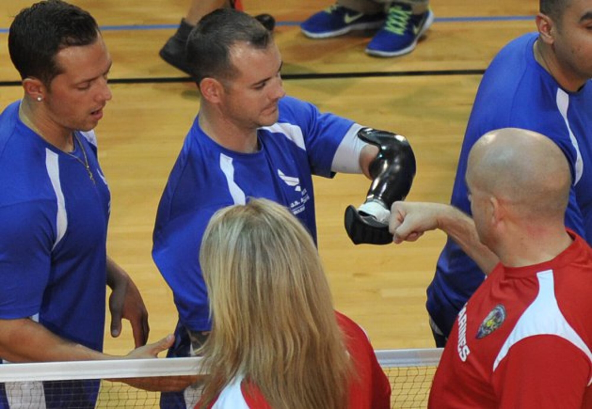 An Air Force wounded warrior congratulates a Marine Corps wounded warrior following the battle for first place at the 3rd Annual Joint Services Sitting Volleyball Tournament, at the Pentagon, Nov. 21, 2013, in recognition of Warrior Care Month. The Marines won the tournament trophy. (U.S. Air Force photo/J.D. Leipold)
