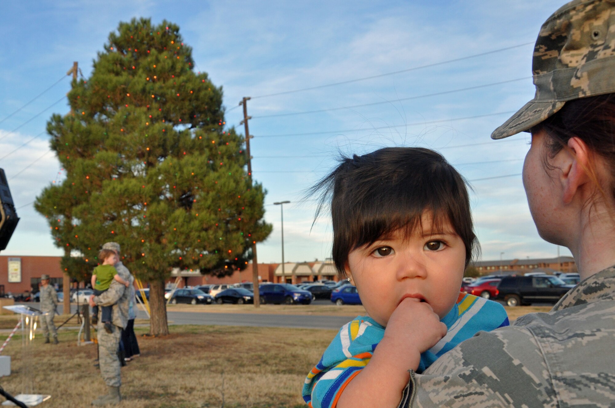 GOODFELLOW AIR FORCE BASE, Texas – A service member stands with her daughter during the Holiday Tree Lighting Ceremony at the base chapel Dec. 3. Children of all ages were invited to see the tree lighting and visit with Santa Claus. (U.S. Air Force photo/ Airman 1st Class Breonna Veal)