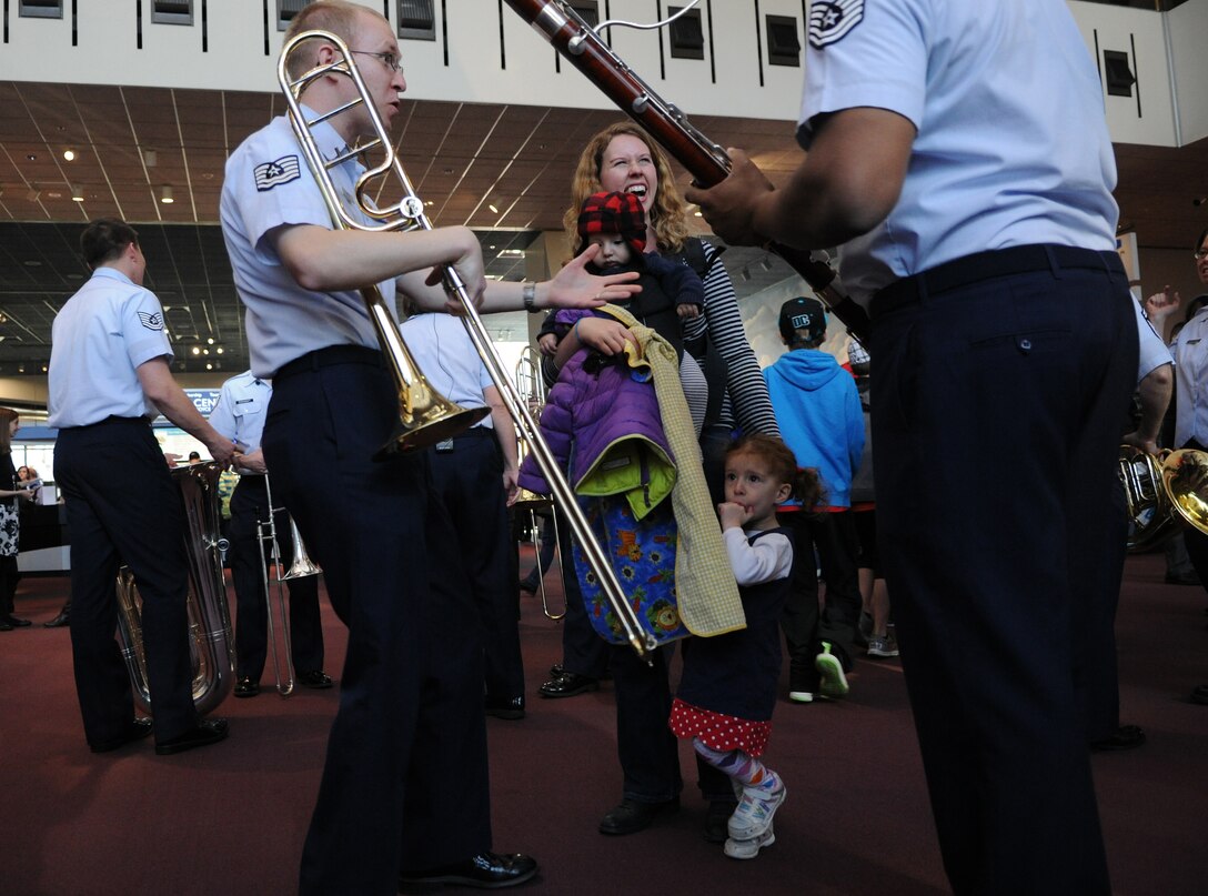 Spectators interact with The United States Air Force Band members after their flash mob performance at The Smithsonian's National Air and Space Museum, Washington, D.C., Dec. 3, 2013. The band surprised museum visitors by breaking out in holiday songs to spread the word about their free upcoming holiday concerts in the National Capitol Region. The National Air and Space Museum welcomes on average eight million people annually, making it the most visited museum complex in the country.  (U.S. Air Force photo by/ Airman 1st Class Nesha Humes)