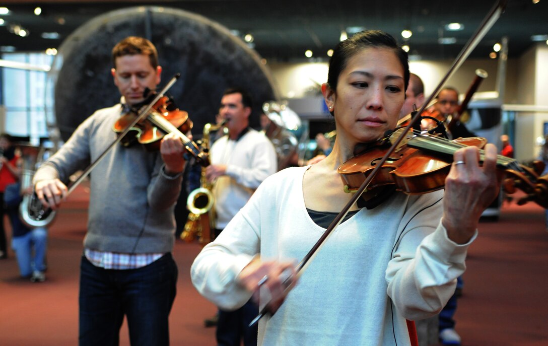 Master Sgt. Mari Uehara Washington, The United States Air Force Band Air Force Strings concertmaster, rehearses for a flash mob at the Smithsonian's National Air and Space Museum Washington, D.C., Dec. 3, 2013. The band played holiday songs to spread the word about their free upcoming holiday concerts in the National Capitol Region. Their mission is to honor those who have served, inspire American citizens to heightened patriotism and service, and positively impacts the global community on behalf of the U.S. Air Force and the United States of America. (U.S. Air Force photo by/ Airman 1st Class Nesha Humes)