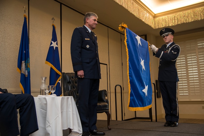 Lt. Gen. Samuel Cox, Operations and Plans Director of U.S. Transportation Command, watches as Airman 1st Class Jason Reyes, Joint Base Charleston Honor Guard, unfurls a three-star general flag during his promotion ceremony Dec. 2, 2013, at the Charleston Club on Joint Base Charleston - Air Base. Cox will be leaving his position as USTRANSCOM Operations and Plans Director to assume his new responsibilities as Deputy Chief of Staff, Manpower, Personnel and Services, Headquarters U.S. Air Force, the Pentagon, Washington, D.C. (U.S. Air Force photo/Tech. Sgt. Rasheen Douglas)