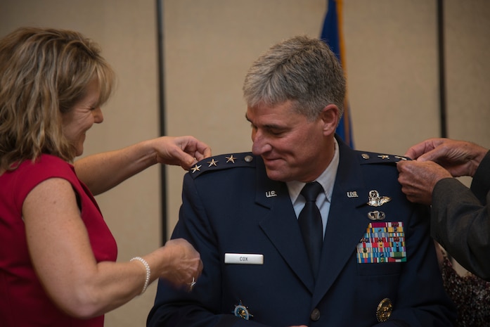 Lt. Gen. Samuel Cox, Operations and Plans Director of U.S. Transportation Command, kneels as wife Tammy and his father, retired Air Force Maj. Jerry Cox, pin on his third star during his promotion ceremony Dec. 2, 2013, at the Charleston Club on Joint Base Charleston - Air Base. Cox will be leaving the position of USTRANSCOM Operations and Plans Director to assume his new responsibilities as Deputy Chief of Staff, Manpower, Personnel and Services, Headquarters U.S. Air Force, the Pentagon, Washington, D.C. (U.S. Air Force photo/Tech. Sgt. Rasheen Douglas)