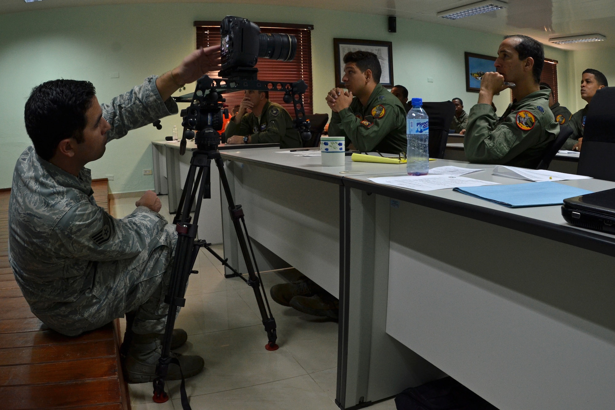 Staff Sgt. Kuris Villavencencio, a videographer with the 2nd Combat Camera Squadron, documents discussions on air-to-air intercept tactics between U.S. and Dominican Republic airmen as part of an exercise to combat illegal drug trafficking Dec. 3, 2013. The exercise is part of the Sovereign Skies Expansion Program, an initiative between the U.S., Colombian, and Dominican Republic air forces to share best-practices on procedures to detect, track and intercept illegal drugs moving north from South America. (U.S. Air Force photo by Capt. Justin Brockhoff/Released)








