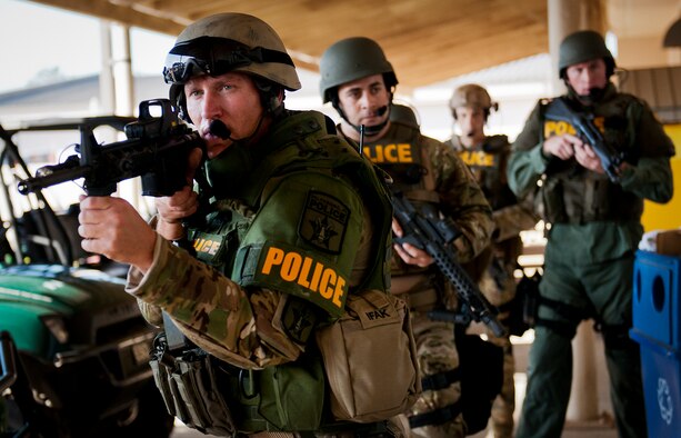 Members of the Crestview Police Department SWAT advance toward an outer door of the Naval School Explosive Ordnance Disposal building during an active shooter exercise on Eglin Air Force Base, Fla., Dec. 3. Police and first responders from Eglin and the surrounding communities participated in the joint exercise in which a person with two weapons entered the building and began shooting students.  The SWAT team made sure the building was safe to enter.  Then firefighters moved the victims out to the triage area where local emergency medical technicians provided care.  (U.S. Air Force photo/Samuel King Jr.)