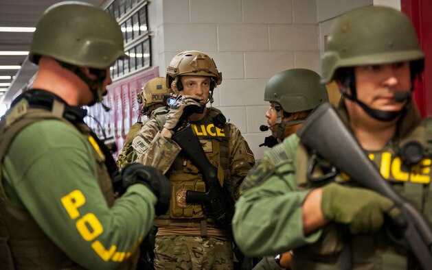 Patrol Officer Lucas Kraus calls into his command center with a status update after his Crestview Police Department SWAT team cleared the Naval School Explosive Ordnance Disposal building during an active shooter exercise on Eglin Air Force Base, Fla., Dec. 3. Police and first responders from Eglin and the surrounding communities participated in the joint exercise in which a person with two weapons entered the building and began shooting students.  The SWAT team made sure the building was safe to enter.  Then firefighters moved the victims out to the triage area where local emergency medical technicians provided care.  (U.S. Air Force photo/Samuel King Jr.)