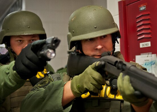 Members of the Crestview Police Department SWAT guard a door as their team members clear a room at the Naval School Explosive Ordnance Disposal building during an active shooter exercise on Eglin Air Force Base, Fla., Dec. 3. Police and first responders from Eglin and the surrounding communities participated in the joint exercise in which a person with two weapons entered the building and began shooting students.  The SWAT team made sure the building was safe to enter.  Then firefighters moved the victims out to the triage area where local emergency medical technicians provided care.  (U.S. Air Force photo/Samuel King Jr.)