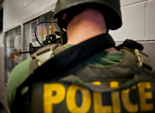 A member of the Crestview Police Department SWAT waits for the rest of his team members to clear a room at the Naval School Explosive Ordnance Disposal building during an active shooter exercise on Eglin Air Force Base, Fla., Dec. 3. Police and first responders from Eglin and the surrounding communities participated in the joint exercise in which a person with two weapons entered the building and began shooting students.  The SWAT team made sure the building was safe to enter.  Then firefighters moved the victims out to the triage area where local emergency medical technicians provided care.  (U.S. Air Force photo/Samuel King Jr.)