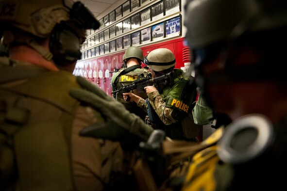 Members of the Crestview Police Department SWAT stay in a tight formation while moving through the hallways of the Naval School Explosive Ordnance Disposal building during an active shooter exercise on Eglin Air Force Base, Fla., Dec. 3. Police and first responders from Eglin and the surrounding communities participated in the joint exercise in which a person with two weapons entered the building and began shooting students.  The SWAT team made sure the building was safe to enter.  Then firefighters moved the victims out to the triage area where local emergency medical technicians provided care.  (U.S. Air Force photo/Samuel King Jr.)