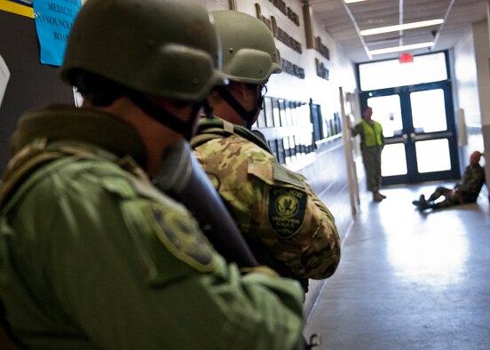 Members of the Crestview Police Department SWAT advance toward a simulated victim at the Naval School Explosive Ordnance Disposal building during an active shooter exercise on Eglin Air Force Base, Fla., Dec. 3. Police and first responders from Eglin and the surrounding communities participated in the joint exercise in which a person with two weapons entered the building and began shooting students.  The SWAT team made sure the building was safe to enter.  Then firefighters moved the victims out to the triage area where local emergency medical technicians provided care.  (U.S. Air Force photo/Samuel King Jr.)