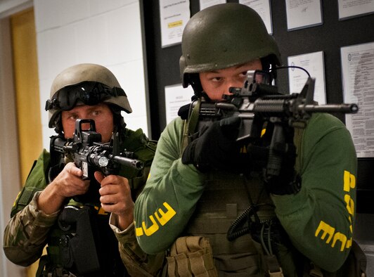 Members of the Crestview Police Department SWAT guard a door as their team members clear a room at the Naval School Explosive Ordnance Disposal building during an active shooter exercise on Eglin Air Force Base, Fla., Dec. 3. Police and first responders from Eglin and the surrounding communities participated in the joint exercise in which a person with two weapons entered the building and began shooting students.  The SWAT team made sure the building was safe to enter.  Then firefighters moved the victims out to the triage area where local emergency medical technicians provided care.  (U.S. Air Force photo/Samuel King Jr.)