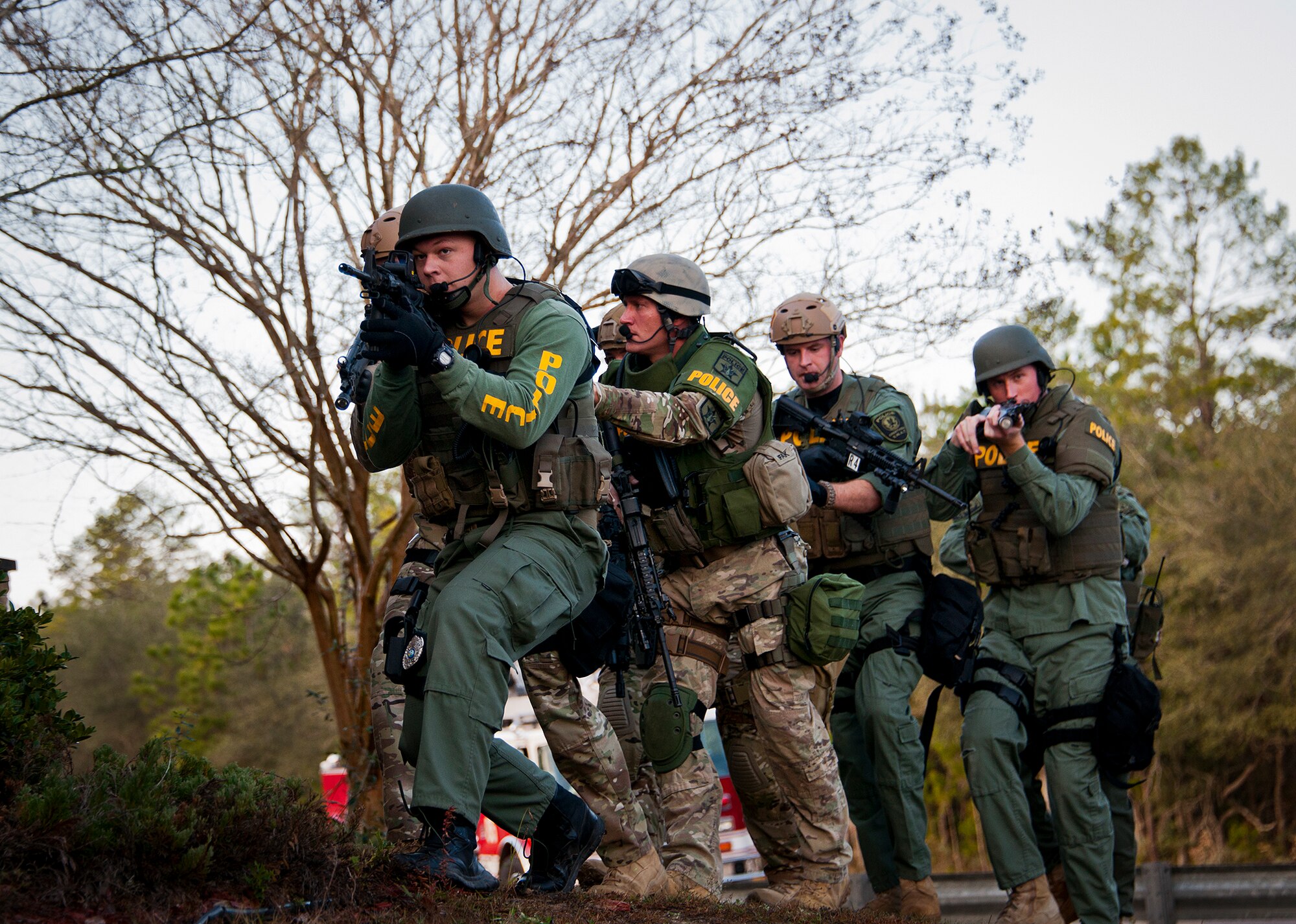 Members of the Crestview Police Department SWAT team move toward an entrance of the Naval School Explosive Ordnance Disposal building during an active shooter exercise on Eglin Air Force Base, Fla., Dec. 3. Police and first responders from Eglin and the surrounding communities participated in the joint exercise in which a person with two weapons entered the building and began shooting students.  The SWAT team made sure the building was safe to enter.  Then firefighters moved the victims out to the triage area where local emergency medical technicians provided care.  (U.S. Air Force photo/Samuel King Jr.)
