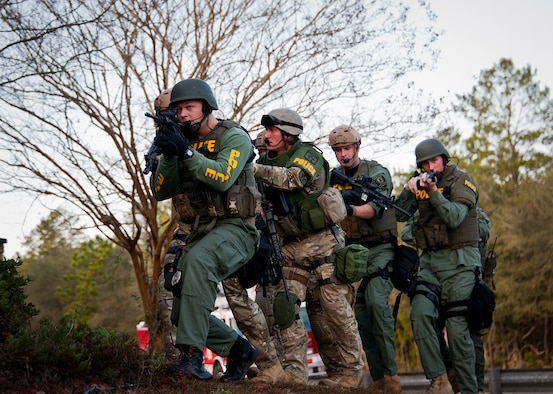 Members of the Crestview Police Department SWAT team move toward an entrance of the Naval School Explosive Ordnance Disposal building during an active shooter exercise on Eglin Air Force Base, Fla., Dec. 3. Police and first responders from Eglin and the surrounding communities participated in the joint exercise in which a person with two weapons entered the building and began shooting students.  The SWAT team made sure the building was safe to enter.  Then firefighters moved the victims out to the triage area where local emergency medical technicians provided care.  (U.S. Air Force photo/Samuel King Jr.)