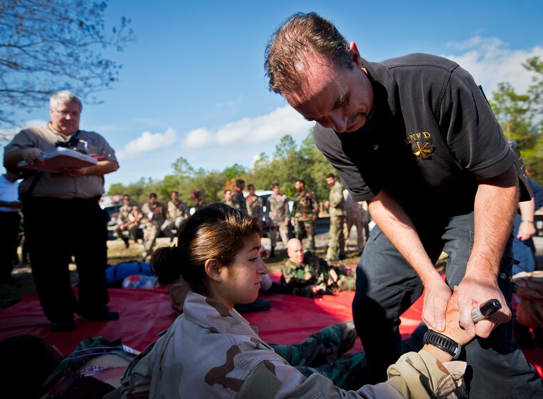 David Birch, an East Niceville emergency medical technician, labels a simulated victim with a number to help maintain accountability and determine treatment during an active shooter exercise at the Naval School Explosive Ordnance Disposal building Dec. 3. Police and first responders from Eglin and the surrounding communities participated in the joint exercise in which a person with two weapons entered the building and began shooting students.  The SWAT team made sure the building was safe to enter.  Then firefighters moved the victims out to the triage area where local emergency medical technicians provided care.  (U.S. Air Force photo/Samuel King Jr.)