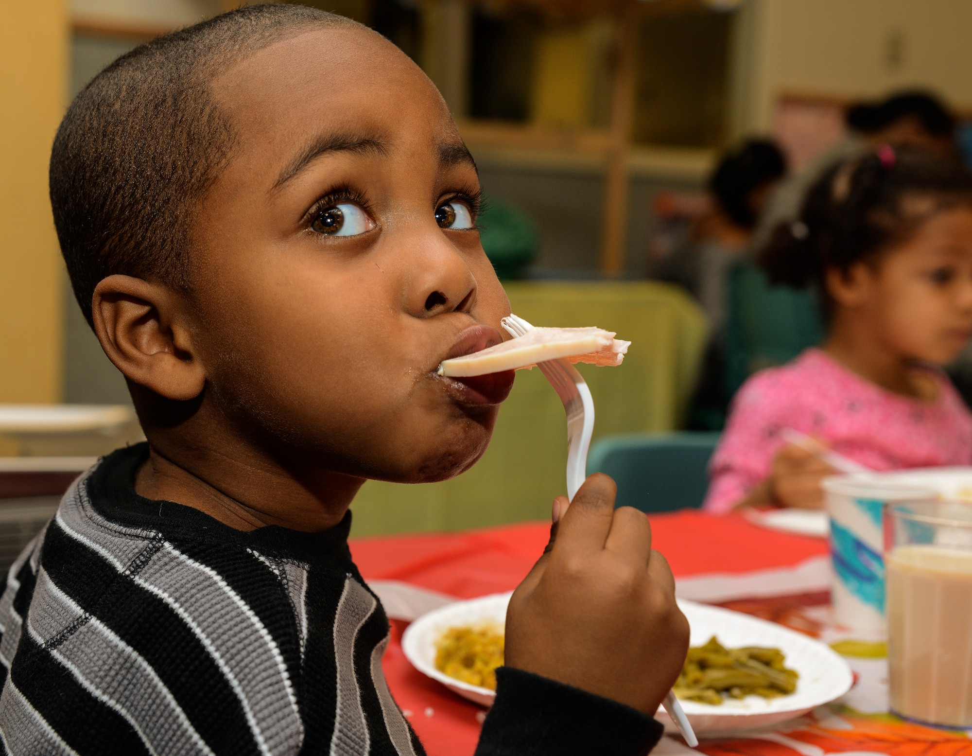 Three-year old Charles Brown III, son of Technical Sgt. Charles Brown Jr., 628th Logistics Readiness Squadron assistant non-commissioned officer in charge of customer support, eats a piece of turkey during a Thanksgiving lunch held by the Child Development Center Nov. 21, 2013, at JB Charleston – Air Base, S.C. The CDC has held this event for more than 16 years. The children and their parents enjoyed turkey, dressing, candy yams, green beans, rolls and apple and potato pie. (U.S. Air Force photo/ Airman 1st Class Chacarra Neal)
