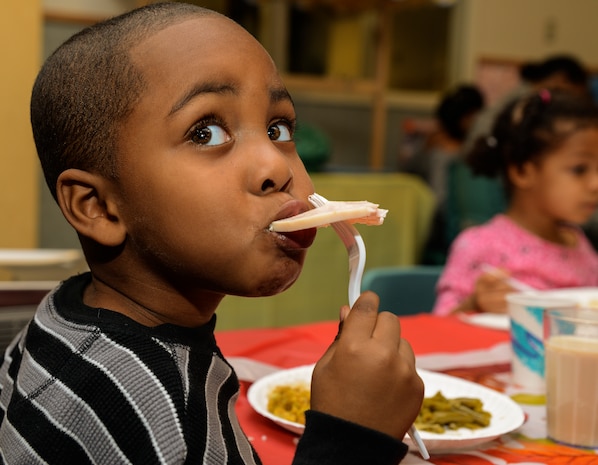 Three-year old Charles Brown III, son of Technical Sgt. Charles Brown Jr., 628th Logistics Readiness Squadron assistant non-commissioned officer in charge of customer support, eats a piece of turkey during a Thanksgiving lunch held by the Child Development Center Nov. 21, 2013, at JB Charleston – Air Base, S.C. The CDC has held this event for more than 16 years. The children and their parents enjoyed turkey, dressing, candy yams, green beans, rolls and apple and potato pie. (U.S. Air Force photo/ Airman 1st Class Chacarra Neal)