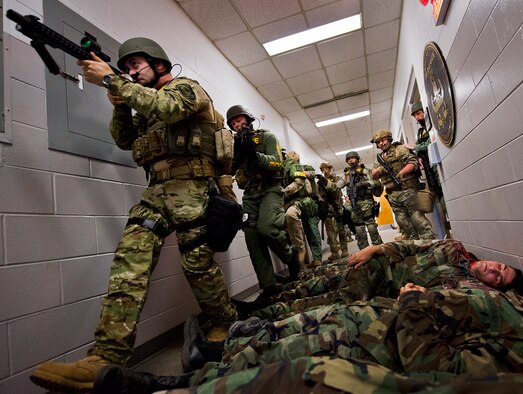Members of the Crestview Police Department SWAT team move past the bodies of simulated victims to clear the Naval School Explosive Ordnance Disposal building during an active shooter exercise on Eglin Air Force Base, Fla., Dec. 3. Police and first responders from Eglin and the surrounding communities participated in the joint exercise in which a person with two weapons entered the building and began shooting students.  The SWAT team made sure the building was safe to enter.  Then firefighters moved the victims out to the triage area where local emergency medical technicians provided care.  (U.S. Air Force photo/Samuel King Jr.)