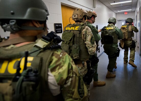 Members of the Crestview Police Department SWAT team clear the rooms of the Naval School Explosive Ordnance Disposal building during an active shooter exercise on Eglin Air Force Base, Fla., Dec. 3. Police and first responders from Eglin and the surrounding communities participated in the joint exercise in which a person with two weapons entered the building and began shooting students.  The SWAT team made sure the building was safe to enter.  Then firefighters moved the victims out to the triage area where local emergency medical technicians provided care.  (U.S. Air Force photo/Samuel King Jr.)