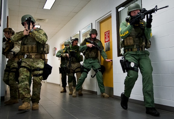 Members of the Crestview Police Department SWAT team clear the rooms of the Naval School Explosive Ordnance Disposal building during an active shooter exercise on Eglin Air Force Base, Fla., Dec. 3. Police and first responders from Eglin and the surrounding communities participated in the joint exercise in which a person with two weapons entered the building and began shooting students.  The SWAT team made sure the building was safe to enter.  Then firefighters moved the victims out to the triage area where local emergency medical technicians provided care.  (U.S. Air Force photo/Samuel King Jr.)