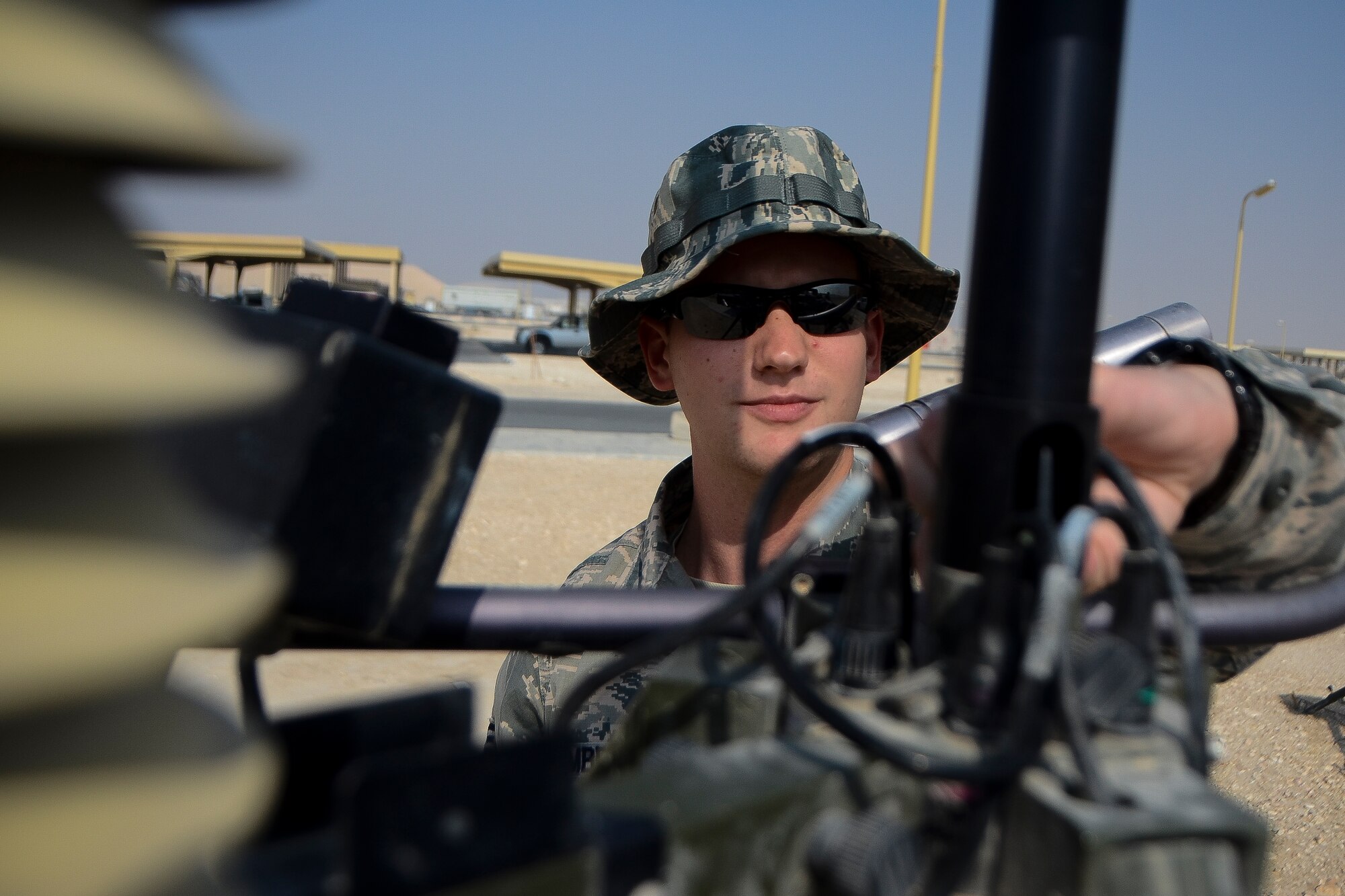Senior Airman Chase Blumberg tightens a connection on a deployable weather sensor at the 379th Air Expeditionary Wing in Southwest Asia, Dec. 2, 2013. To avoid harsh weather conditions and create the safest route possible, weather forecasts help pilots during takeoff, in flight and when landing. Blumberg, a 379th Expeditionary Operations Support Squadron weather flight forecaster, is part of an eight man shop which monitors weather conditions for flight missions around-the-clock. Blumberg is deployed from Davis-Monthan Air Force Base, Ariz. and hails from Ocala, Fla.  (U.S. Air Force photo/Senior Airman Jared Trimarchi) 