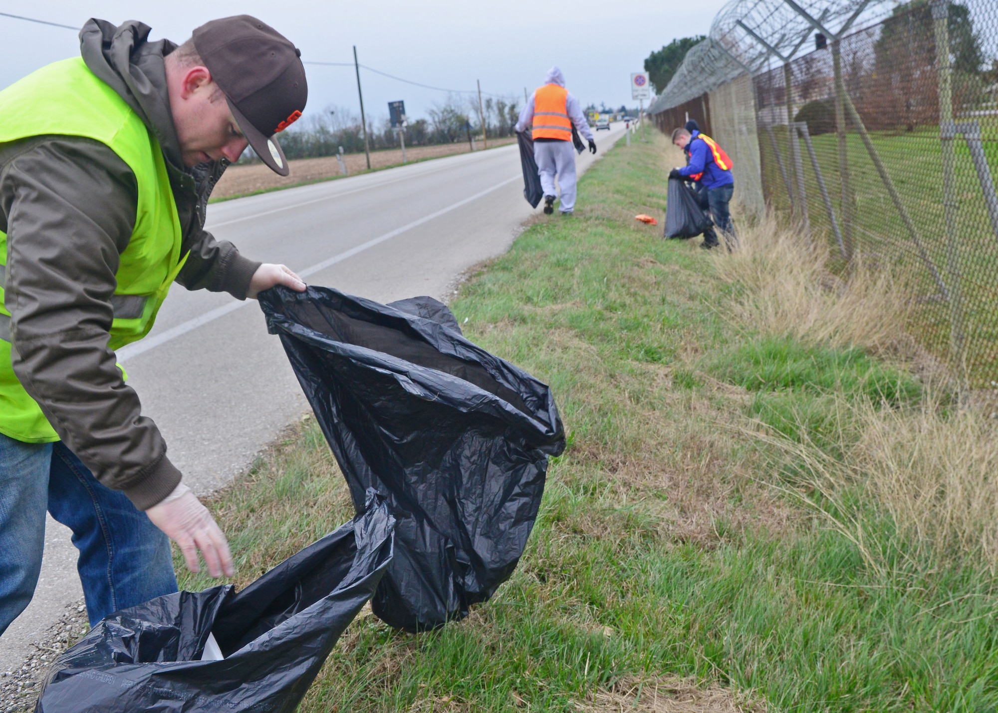 Staff Sgt. Bryce Dick, “Troops on Trash” participant, collects trash along the base perimeter, Nov. 30, 2013, at Aviano Air Base, Italy. Airmen walked from North Gate to South Gate collecting trash and separating glass, paper, aluminum and cardboard into separate trash bags. (U.S. Air Force photo/Senior Airman Briana Jones)