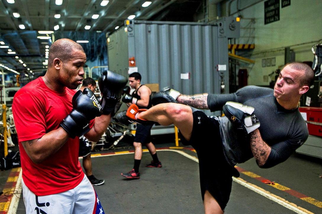 U.S. Navy Airman Jordan Harthman, right, spars with Petty Officer 1st Class Walter Dailey in the hangar bay of the aircraft carrier USS George Washington in the Philippine Sea, Nov. 26, 2013. The Washington and embarked Carrier Air Wing 5 provide a combat-ready force to protect and defend the maritime interest of the U.S. and its allies and partners in the Indo-Asia-Pacific region.