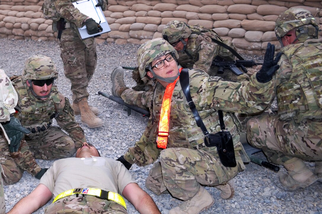 U.S. Army Maj. Elizabeth Gum relays the condition of a simulated casualty to a triage station during a mass casualty exercise on Kandahar Airfield, Afghanistan, Nov. 22, 2013. Gum, a medical liaison officer, is assigned to 82nd Sustainment Brigade, U.S. Central Command Materiel Recovery Element.