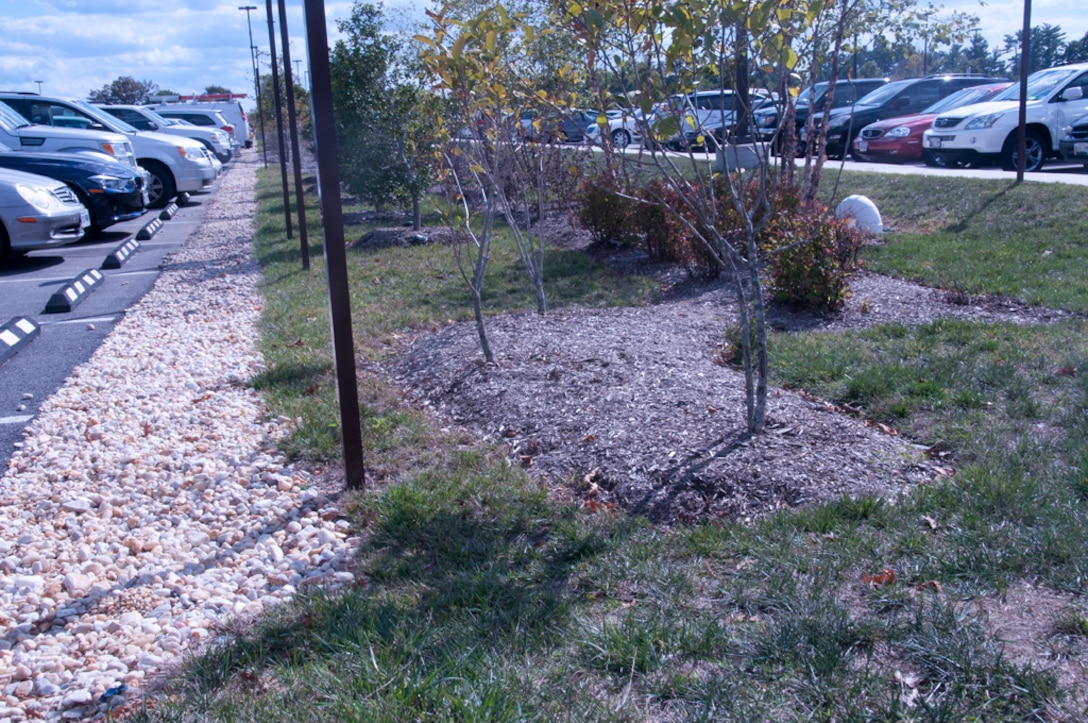 Impervious disconnection - Runoff sheet flows from parking lot to landscape buffer and infiltration trench at Fort Meade, Maryland.