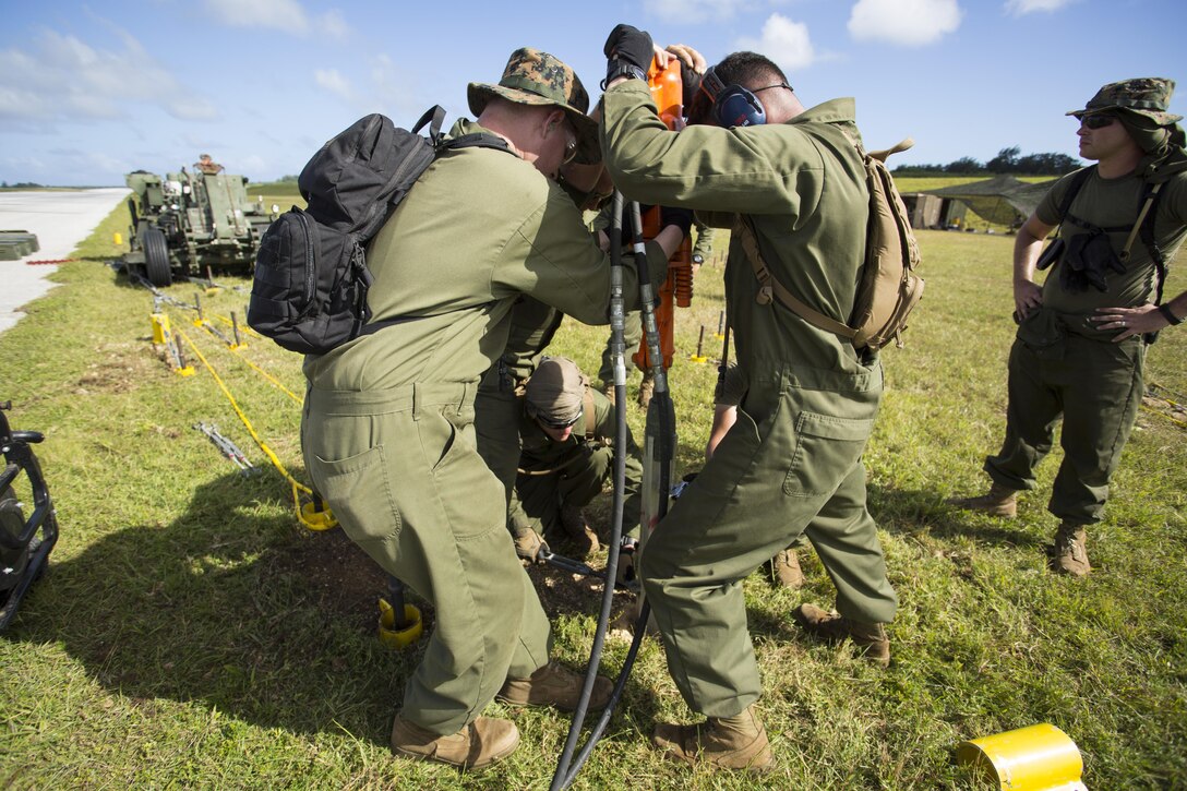 Marines use a jackhammer to place an anchor for an M-31 Marine Corps expeditionary arresting gear system Nov. 22 at Tinian’s West Field during Exercise Forager Fury II. The arresting gear is a dynamic piece of equipment critical to FF II, which is a joint exercise designed to employ and assess combat power generation in a deployed and austere environment. The Marines are expeditionary airfield system technicians with Marine Wing Support Squadron 171, Marine Aircraft Group 12, 1st Marine Aircraft Wing, III Marine Expeditionary Force.