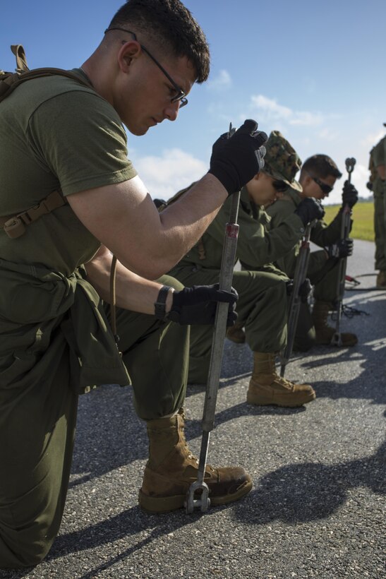 Pfc. Chase Leake, left, Lance Cpl. Stephanie Jordi, middle, and Lance Cpl. Juan Gonzalez, assemble an M-31 Marine Corps Expeditionary Arresting Gear System Nov. 28 at Tinian’s West Field during Exercise Forager Fury II. The arresting gear is a dynamic piece of equipment critical to FF II, which is a joint exercise designed to employ and assess combat power generation in a deployed and austere environment. The Marines are expeditionary airfield system technicians with Marine Wing Support Squadron 171, Marine Aircraft Group 12, 1st Marine Aircraft Wing, III Marine Expeditionary Force.