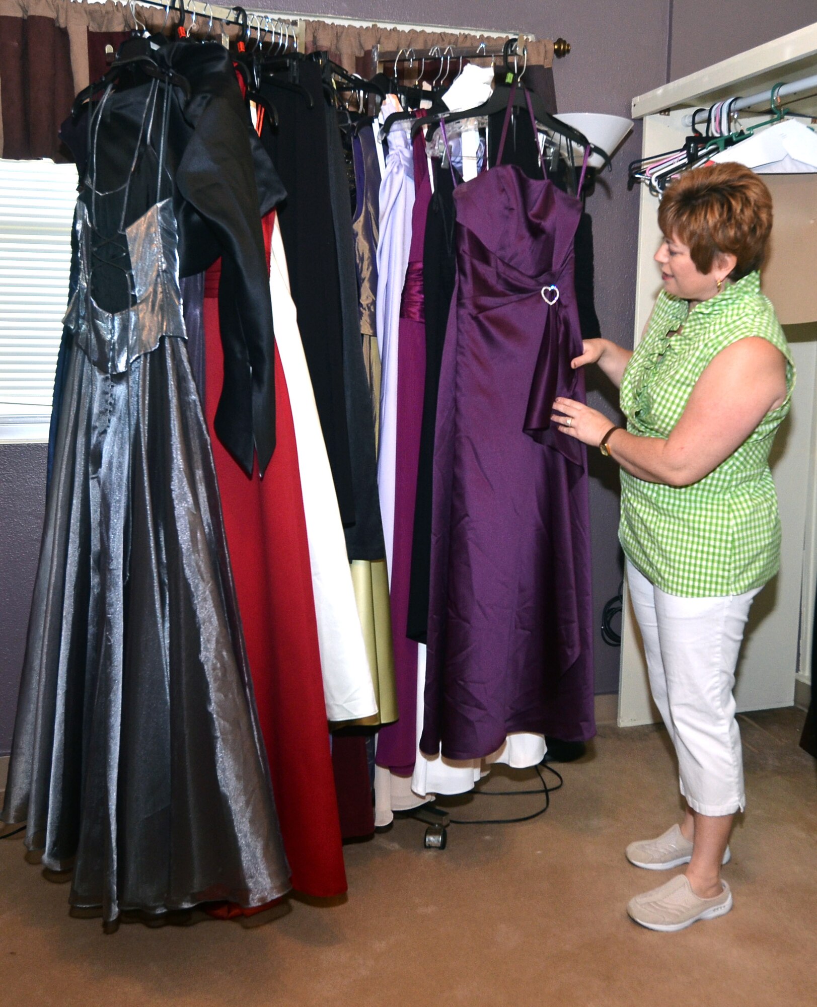 Judy Slisik, Command Chief Master Sgt. Slisik’s wife, looks at a dress in the Cinderella’s Closet at Andersen Air Force Base, Guam, Dec. 3, 2013. The Cinderella’s Closet houses approximately 250 dresses available in a variety of sizes, colors and lengths and can be borrowed by military members or their families for any formal occasion. (U.S. Air Force by Airman 1st Class Mariah Haddenham/Released)