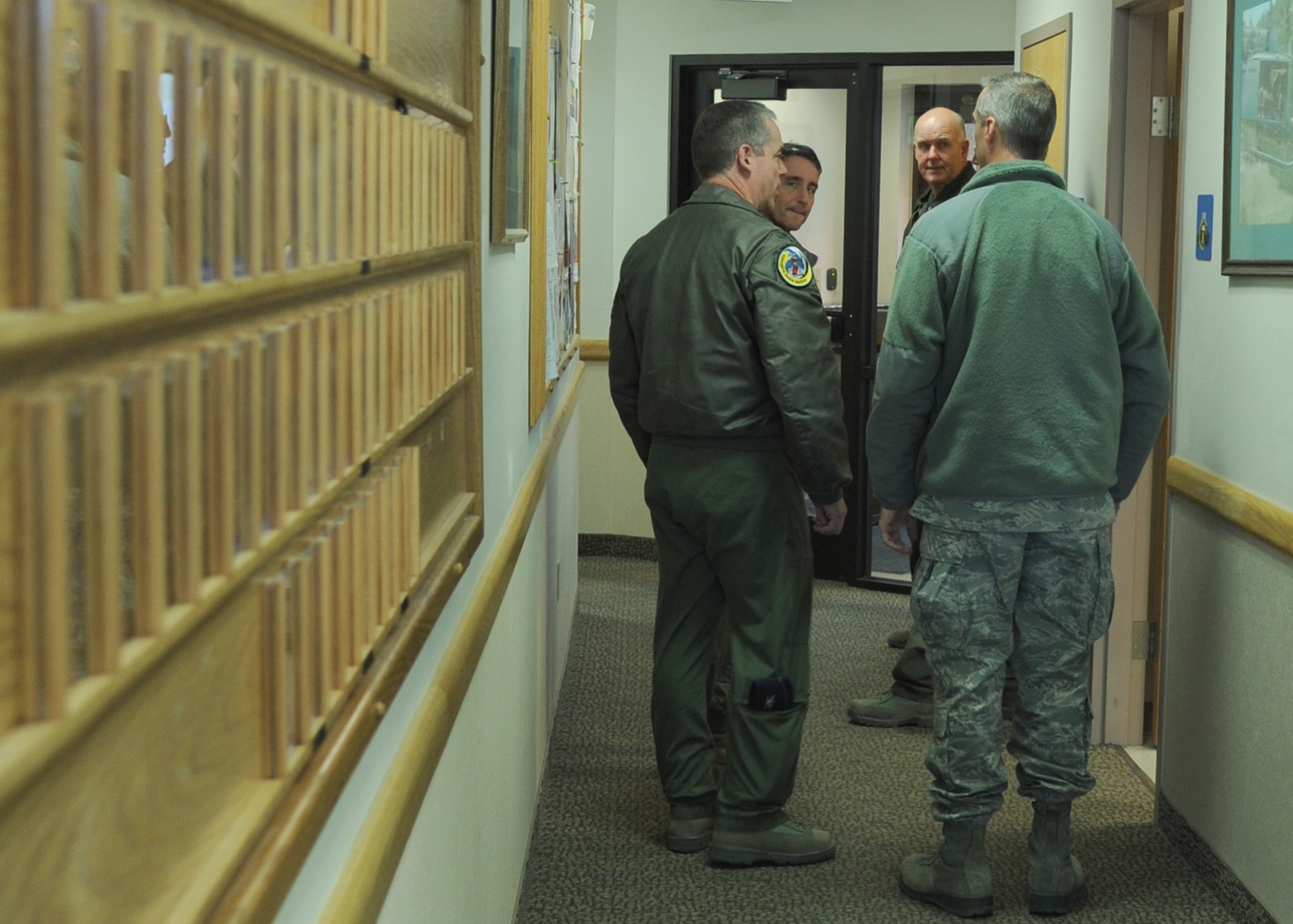 Montana Air National Guard commanders from left to right, Col. Shane Sanders, 120th Operations Group commander; Col. Thomas Mora, 120th Mission Support Group commander; Col. J. Peter Hronek, 120th Fighter Wing commander; and Lt. Col. Patrick Hover, 120th Maintenance Group commander, talk amongst each other before continuing a tour of the 40th Helicopter Squadron on Nov. 26.  Their day-long visit to Malmstrom Air Force Base included tours of the Tactical Response Force shoothouse, T-9 maintenance trainer, a missile alert facility and launch control center.  (U.S. Air Force photo/Senior Airman Cortney Paxton)