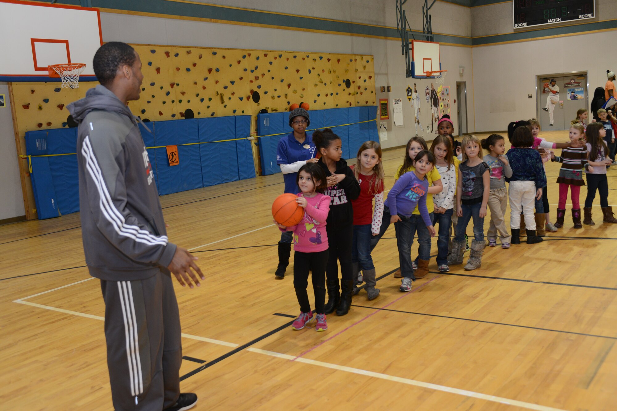 Antoine Hood, Idaho Stampede point guard, teaches basic fundamentals at a basketball clinic for military children Dec. 4, 2013, at Mountain Home Air Force Base, Idaho. The Stampede is an American basketball team that plays in the National Basketball Association Development League based in the Boise, Idaho, area. (U.S. Air Force photo by Senior Airman Benjamin Sutton/Released)