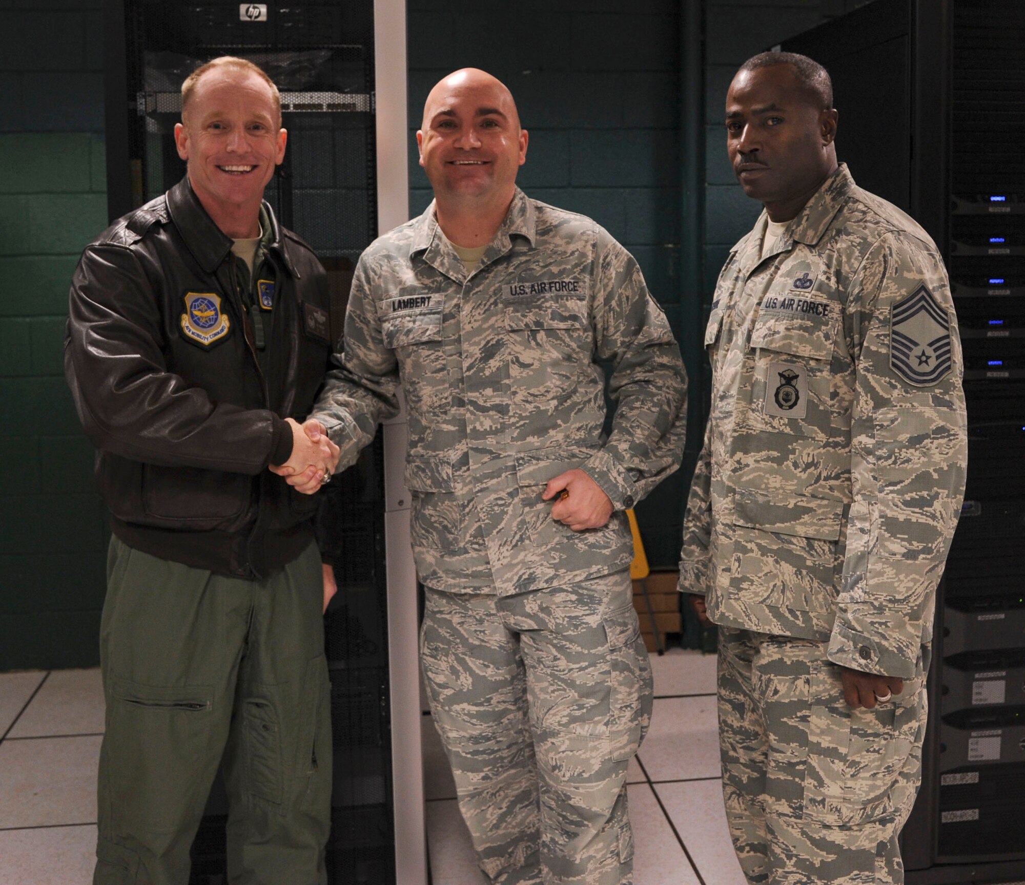 Tech. Sgt. Jacob Lambert, a 189th Airlift Wing cyber systems operations craftsman, is congratulated by Col. Patrick Rhatigan, 19th Airlift Wing commander, for his selection as Combat Airlifter of the Week Nov. 22, 2013, at Little Rock Air Force Base, Ark. Lambert, a Traskwood, Ark., native, has been instrumental in the establishment of Graduate Training Integration Management System connectivity in the 189th Airlift Wing facilities. (U.S. Air Force photo by Airman 1st Class Harry Brexel)