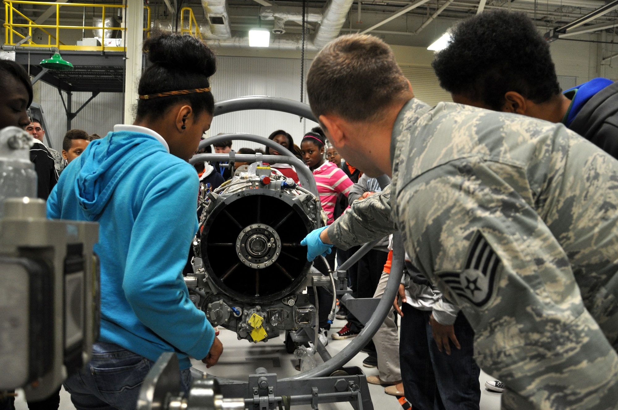Staff Sgt. Kyle Pringle, a 19th Component Maintenance Squadron aerospace propulsion journeyman, shows seventh grade students the parts on a compression module Nov. 21, 2013, at Little Rock Air Force Base, Ark. A total of 90 students from the Cloverdale Aerospace Technology Conversion Charter School came to the base to tour the 19th CMS engine shop, the test cell facility and Heritage Park. (U.S. Air Force photo by Senior Airman Regina Agoha)