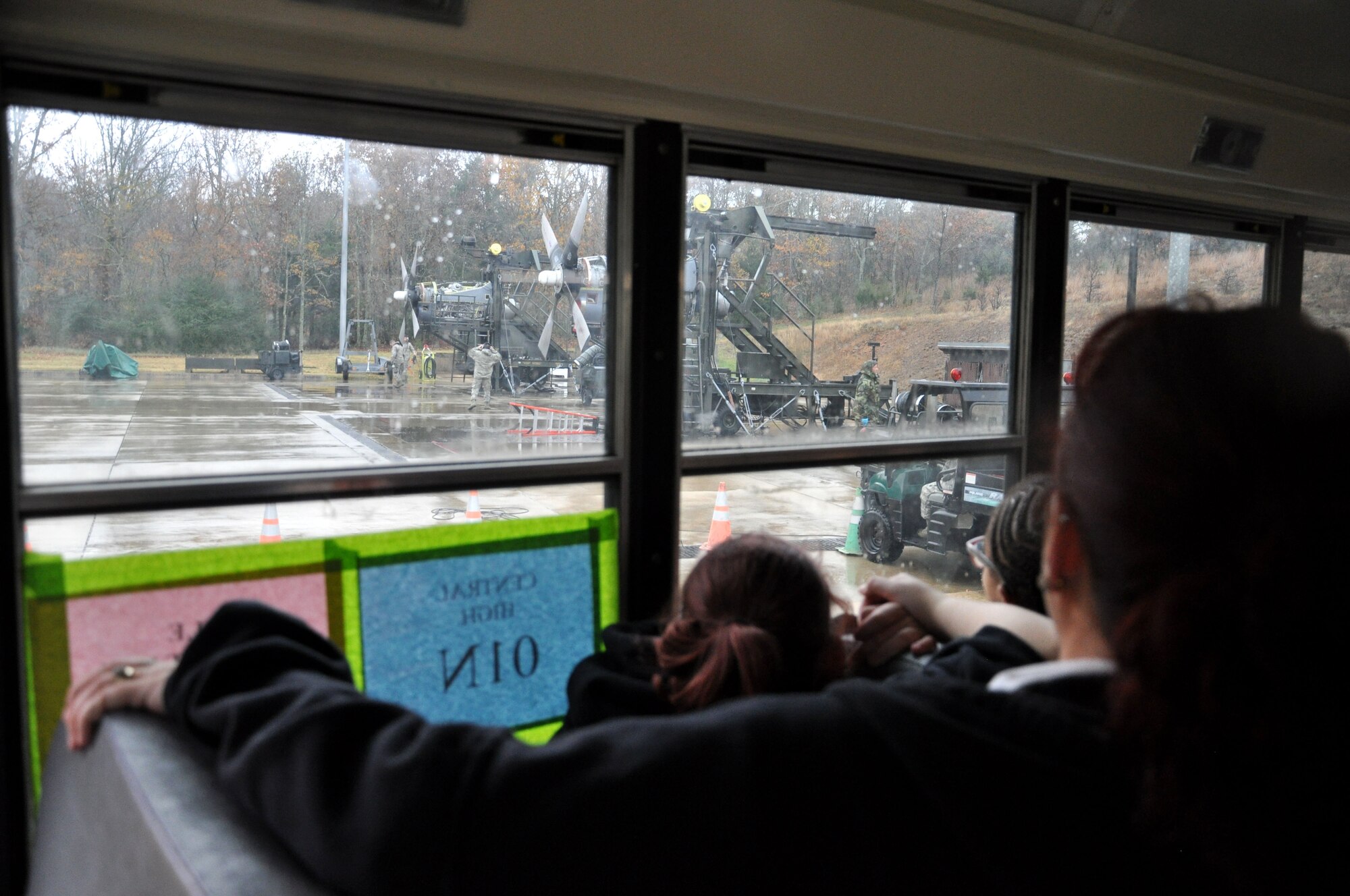 Students watch from their bus as 19th Component Maintenance Squadron Airmen prepare to test an engine Nov. 21, 2013, at Little Rock Air Force Base, Ark. A total of 90 students came to the base to tour the 19th CMS engine shop, the test cell facility and Heritage Park. (U.S. Air Force photo by Senior Airman Regina Agoha)