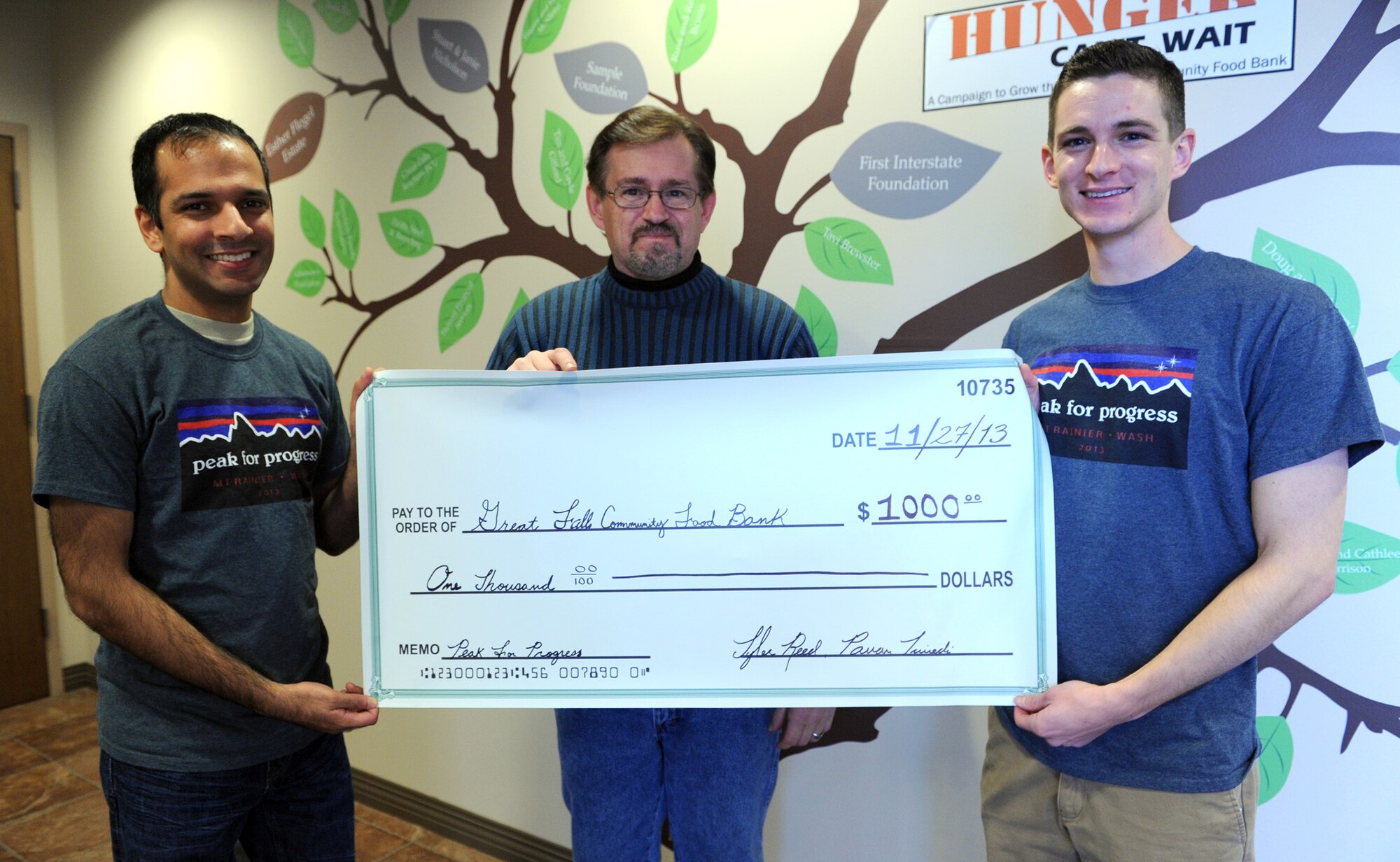 Dave Abbot, Great Falls Food Bank executive director (center), receives a check from 1st Lt. Pavan Trivedi, 341st Operations Support Squadron instructor deputy combat crew commander (left), and 2nd Lt. Tyler Reed, 12th Missile Squadron ICBM deputy combat crew commander, at the food bank Nov. 27. Trivedi and Reed climbed Mount Rainier, Wash., May 30 to June 2 to help raise $1,000 for the food bank, which will help pay for more than 2,000 meals. (U.S. Air Force photo/Senior Airman Katrina Heikkinen)