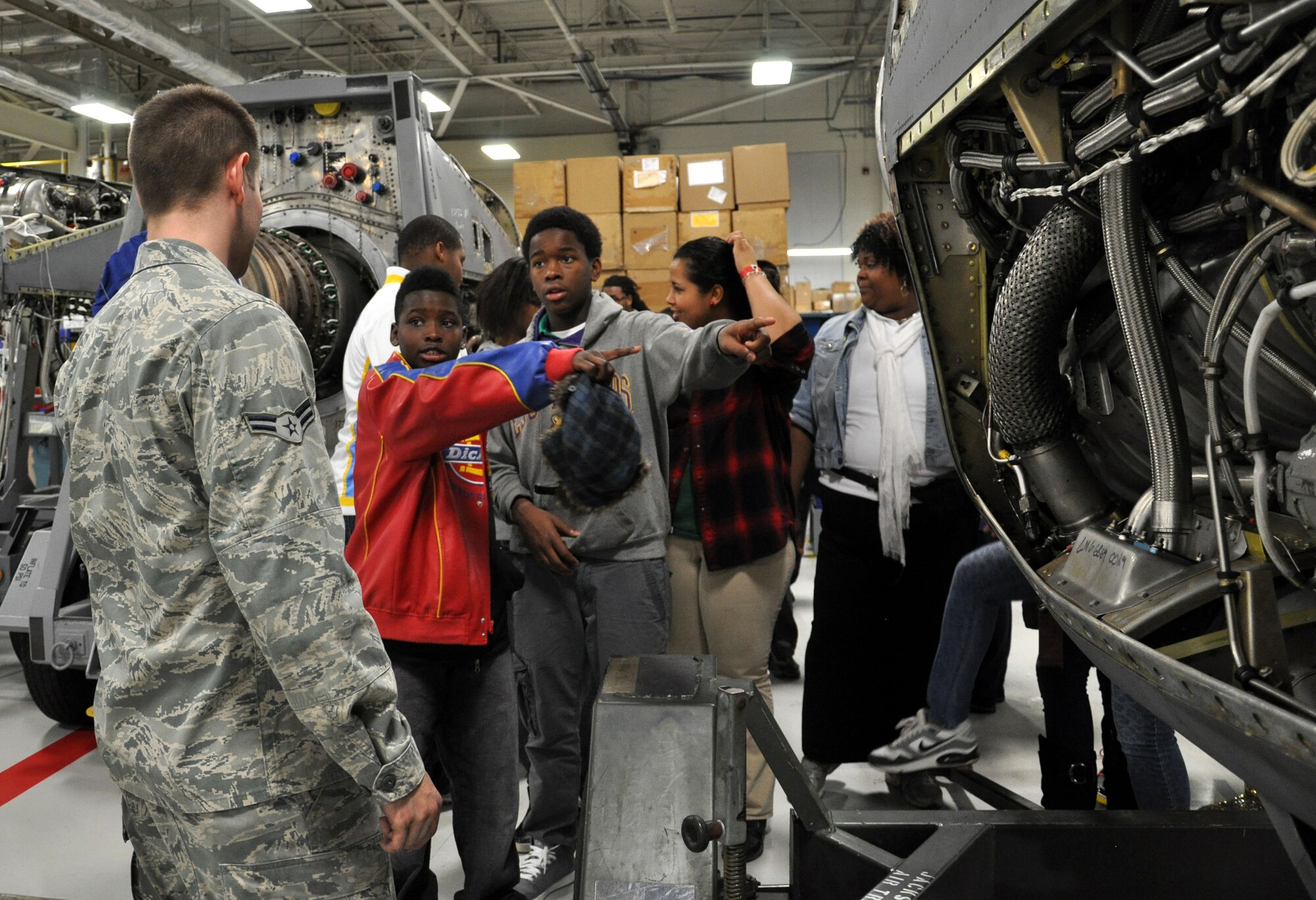 Eighth graders from the Cloverdale Aerospace Technology Conversion Charter School ask questions about the T56-15 engine during their tour at the 19th Component Maintenance Squadron centralized repair facility Nov. 21, 2013, at Little Rock Air Force Base, Ark.  A total of 90 students came to the base to tour the 19th CMS engine shop, the test cell facility and Heritage Park. (U.S. Air Force photo by Senior Airman Regina Agoha)