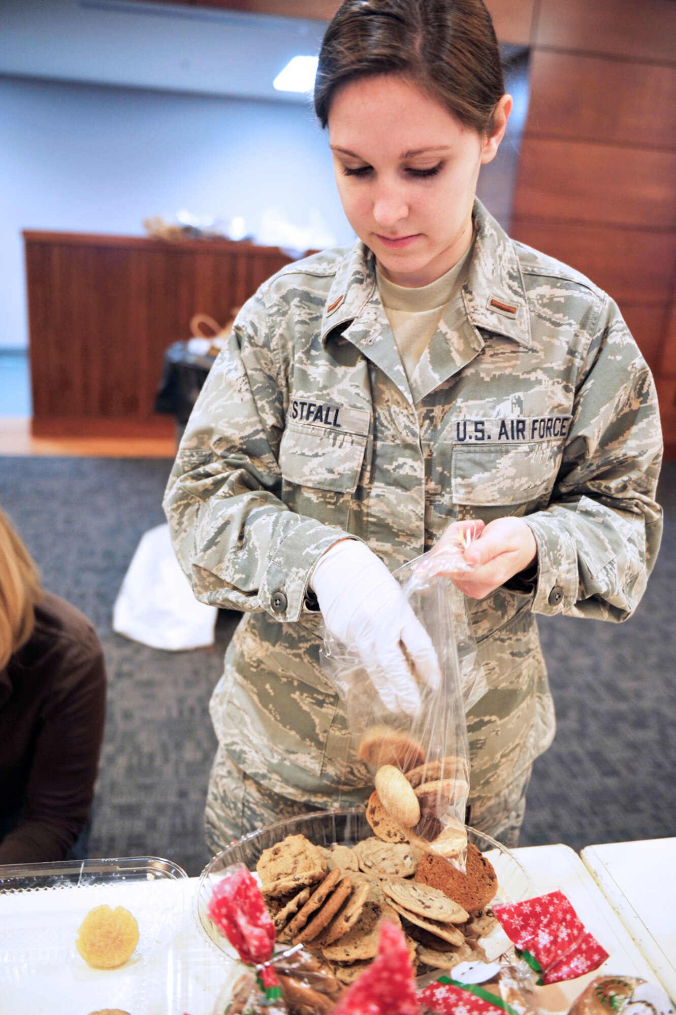 Air Force 2nd Lt. Julia Westfall, 3rd Operation Support Squadron, bags cookies during the annual cookie drive at the Arctic Warrior Event Center on Joint Base Elmendorf-Richardson Dec. 3. Volunteers baked more than 40,000 cookies for single Airmen and Soldiers living in the dormitories and barracks on JBER. (U.S. Air Force photo/Airman 1st Class Tammie Ramsouer)