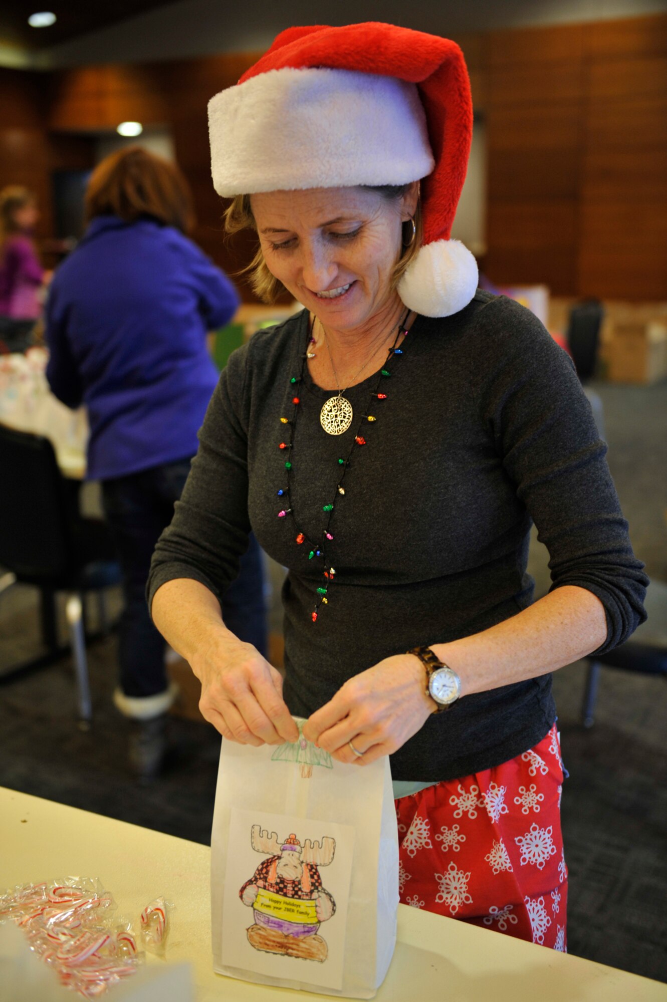 Kim Nahom, closes a bag of cookies during the annual cookie drive at the Arctic Warrior Event Center on Joint Base Elmendorf-Richardson Dec. 3. The cookie drive had more than 30 volunteers and reached their goal of more than 40,000 cookies packaged to be distributed to single Airmen and Soldiers living in the dormitories and barracks on JBER. (U.S. Air Force photo/Airman 1st Class Tammie Ramsouer)