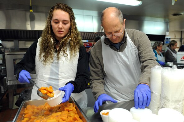 Airman 1st Class Devon Canfield, 819th RED HORSE Squadron heavy equipment operator, scoops cranberry sauce into a cup at the Great Falls Community Food Bank on Nov. 27. More than 60 Team Malmstrom members cooked, prepared and delivered 450 Thanksgiving meals Nov. 27 and 28. (U.S. Air Force photo/Senior Airman Katrina Heikkinen)