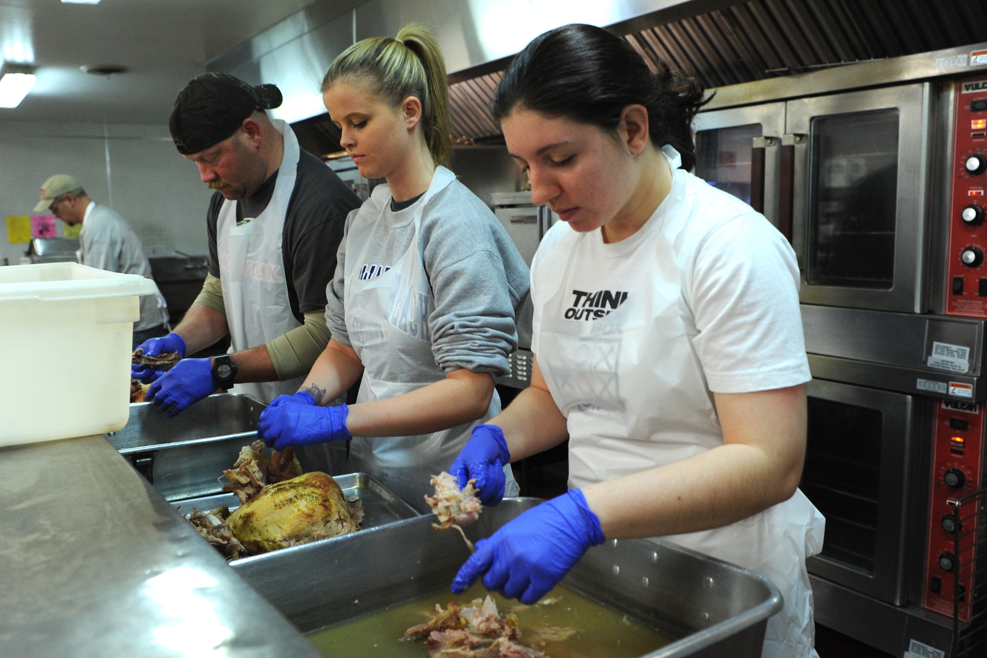 Airmen 1st Class Jessica Brown (center), and Jessica Young, 341st Force Support Squadron force management apprentices, prepare turkey during Operation Thanksgiving at the Great Falls Community Food Bank on Nov. 27. The 341st FSS coordinated the annual event with the food bank to help deliver a record 450 Thanksgiving meals to elderly Great Falls community members. (U.S. Air Force photo/Senior Airman Katrina Heikkinen)