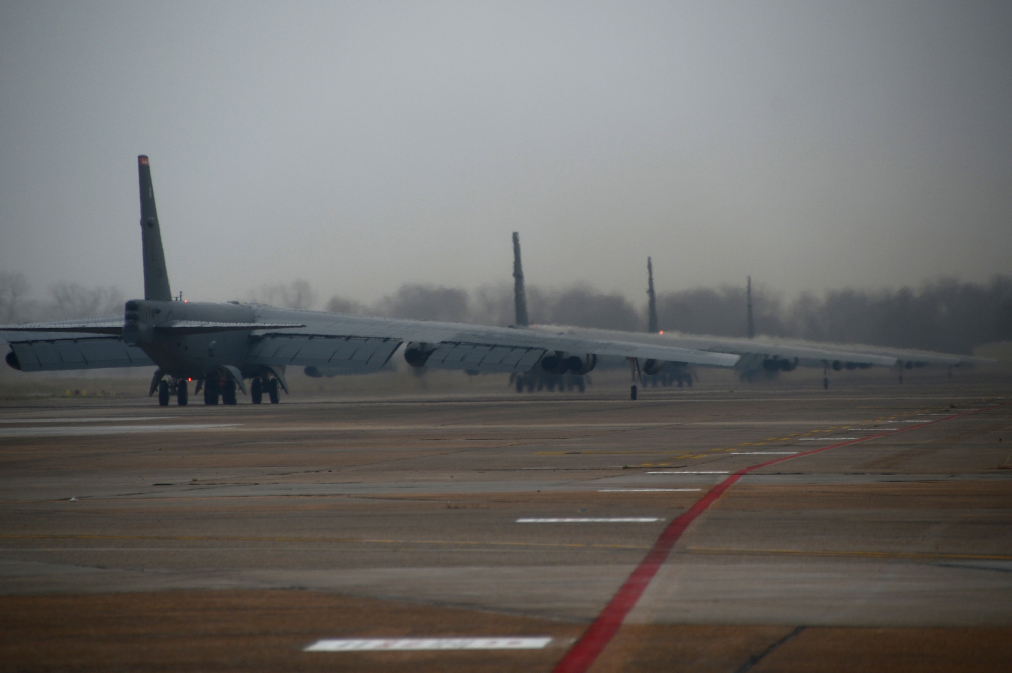 B-52 Stratofortress bombers taxi on the flightline during a minimum interval takeoff on Barksdale Air Force Base, La., Dec. 5, 2013. During a MITO, starter carts filled with gunpowder are used to quickly fire the bomber?s engines for takeoff. The launch procedure allows our deterrent force to respond as rapidly as possible when called upon. (U.S. Air Force photo/Staff Sgt. Amber Corcoran)