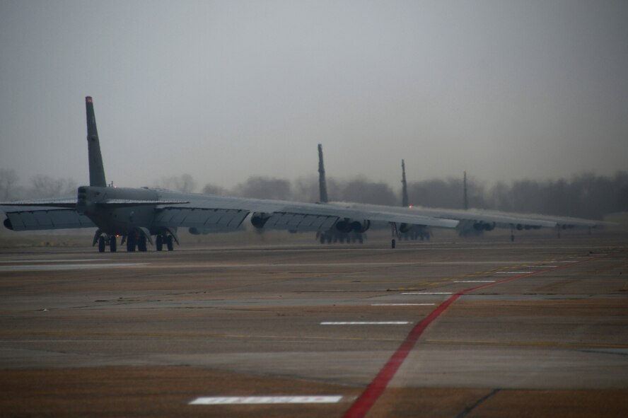 B-52 Stratofortress bombers taxi on the flightline during a minimum interval takeoff on Barksdale Air Force Base, La., Dec. 5, 2013. During a MITO, starter carts filled with gunpowder are used to quickly fire the bomber?s engines for takeoff. The launch procedure allows our deterrent force to respond as rapidly as possible when called upon. (U.S. Air Force photo/Staff Sgt. Amber Corcoran)