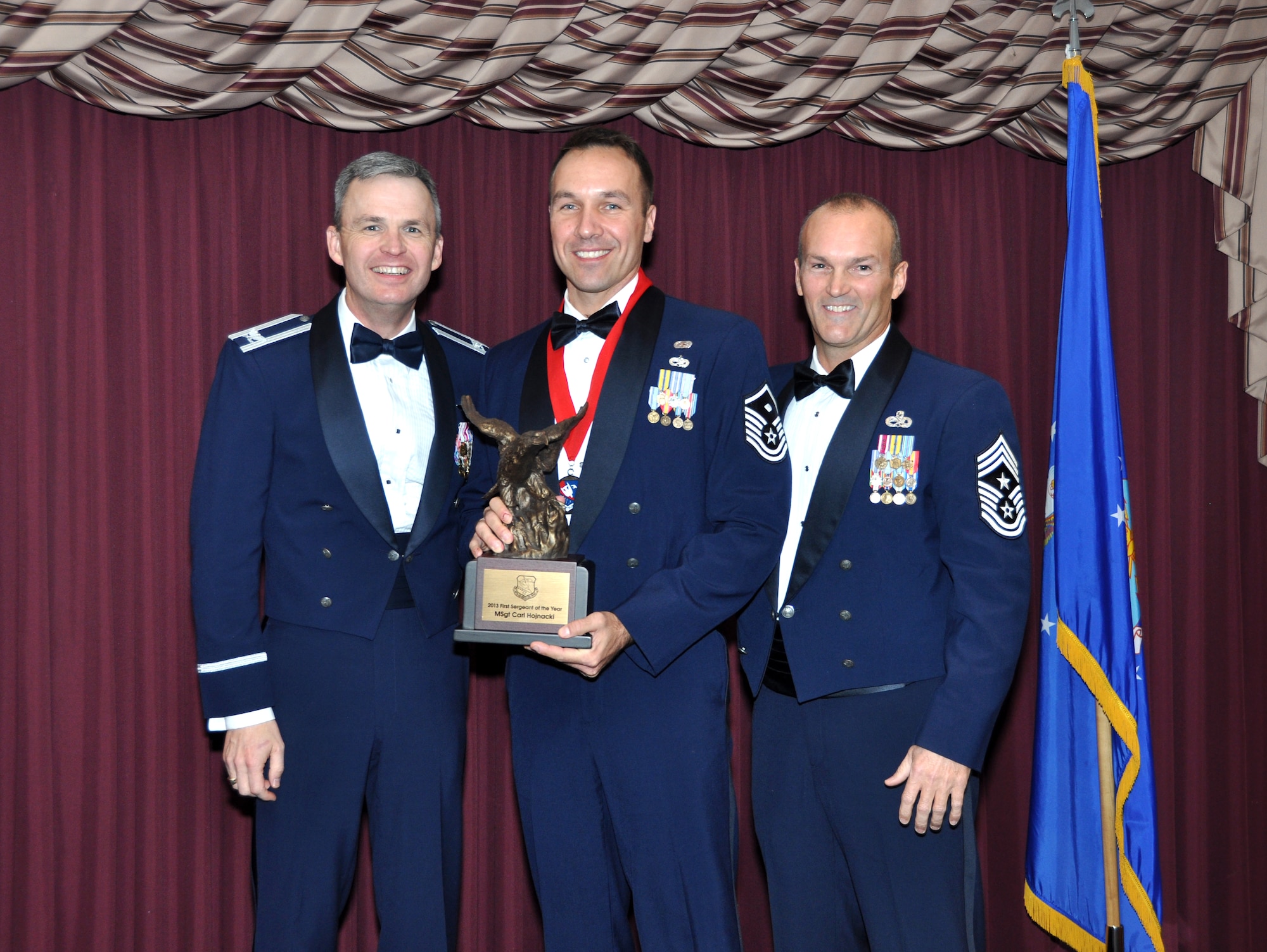 Master Sgt. Carl Hojnacki receives the First Sergeant of the Year Award from 507th Air Refueling Wing acting Commander, Col. Kevin Trayer, left and 507th ARW Command Chief, Chief Master Sgt. Steven Brown during the annual awards banquet at the Tinker club Nov. 23, 2013.  (U.S. Air Force photo/Senior Airman Mark Hybers)