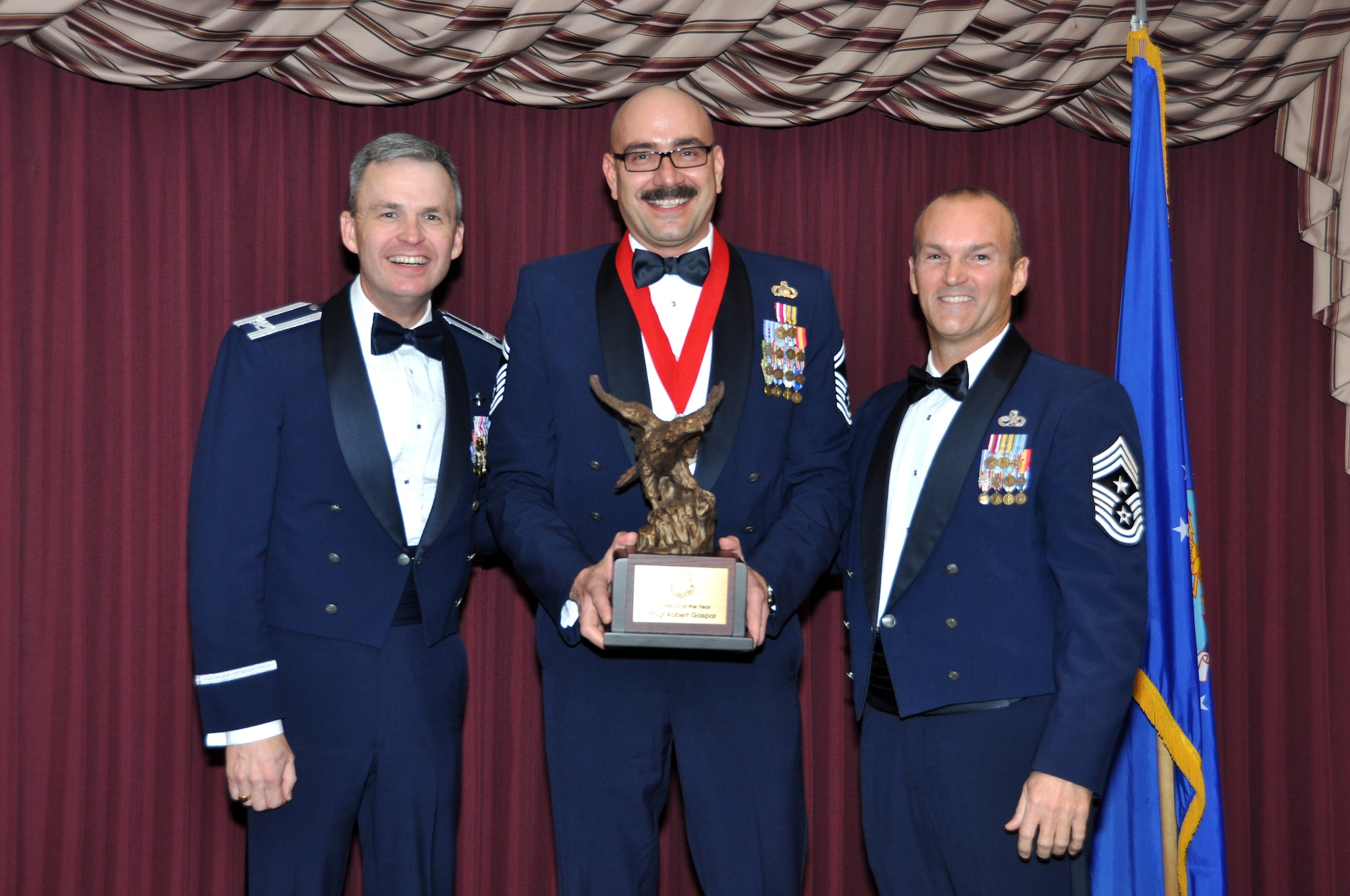 Senior Master Sgt. Robert Gaspar receives the Senior Non-Commissioned Officer of the Year Award from 507th Air Refueling Wing acting Commander, Col. Kevin Trayer, left and 507th ARW Command Chief, Chief Master Sgt. Steven Brown during the annual awards banquet at the Tinker club Nov. 23, 2013.  (U.S. Air Force photo/Senior Airman Mark Hybers)